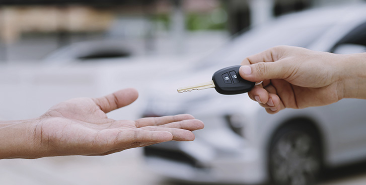 Persona realizando el trámite de cambio de propietario vehicular en una oficina de movilidad.