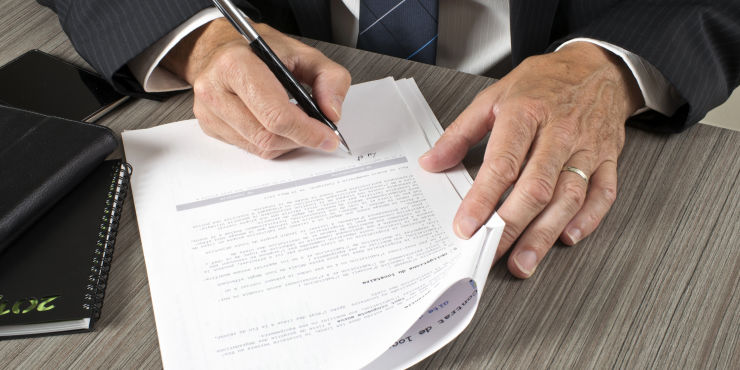 Comprador y vendedor firmando contrato de compraventa de auto usado mexicano 2026 con factura y endoso de la tarjeta de circulación