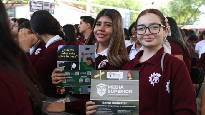 Joven estudiante mexicana de preparatoria consultando su teléfono celular con la página de Becas Benito Juárez abierta