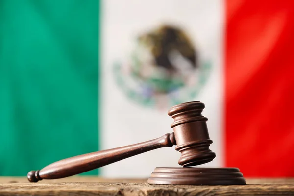 Martillo de juez sobre documentos legales representando laudo favorable en demanda laboral mexicana con billetes y balanza de justicia