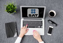 Cancelación del RFC ante el SAT 2026: cuándo conviene hacerla y cómo tramitarla en línea sin cita Persona tramitando la cancelación de su RFC ante el SAT desde una computadora con la pantalla del portal Mi Cuenta SAT abierta