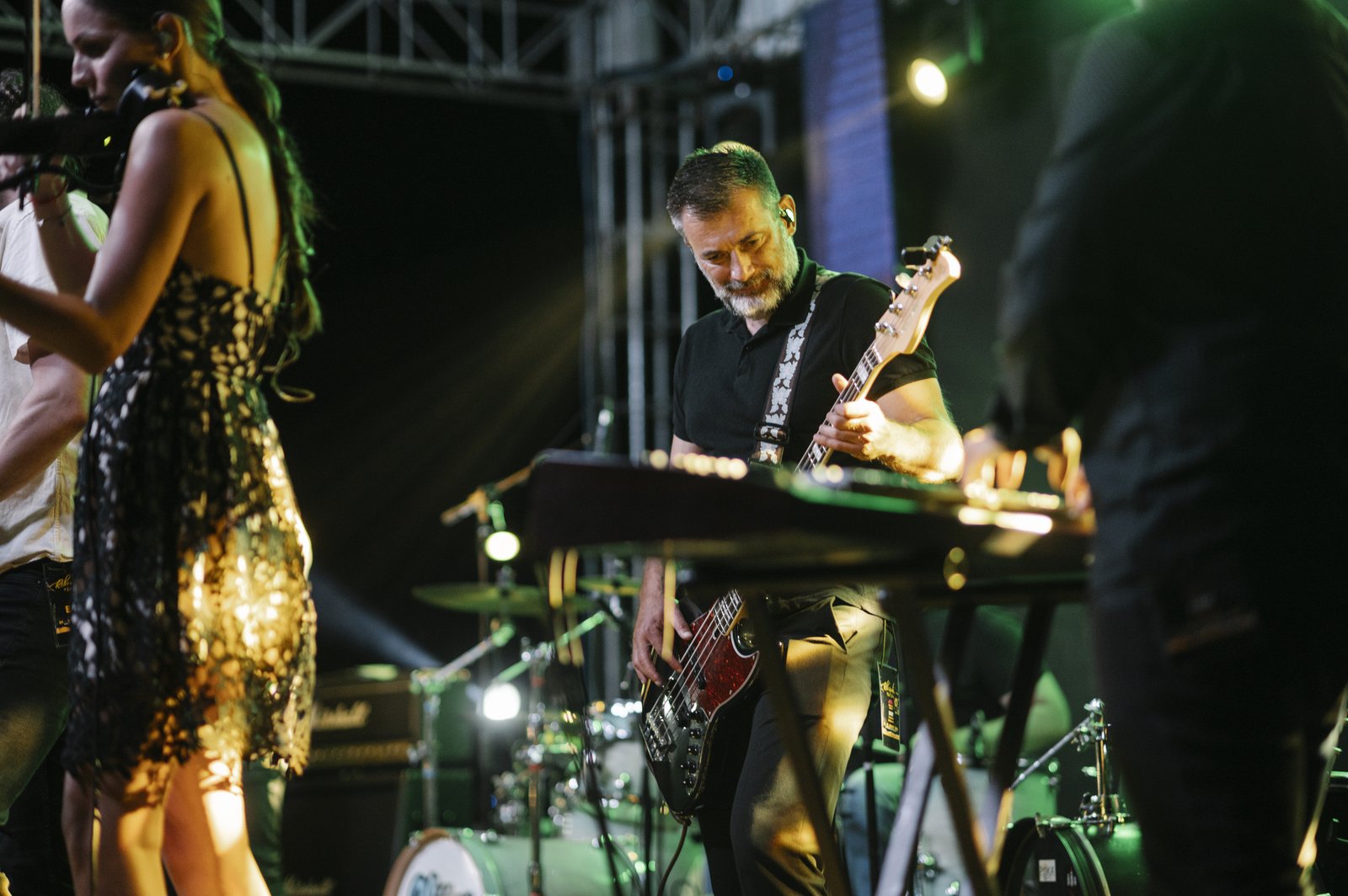 Músicos sobre un escenario iluminado durante un concierto nocturno