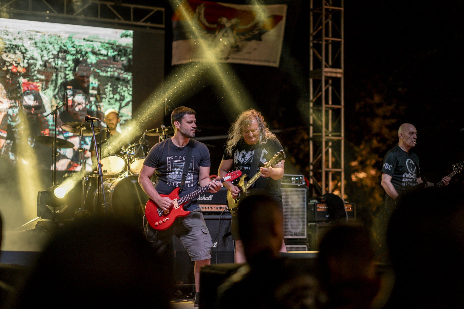 Concierto de rock con guitarras eléctricas y público entusiasta
