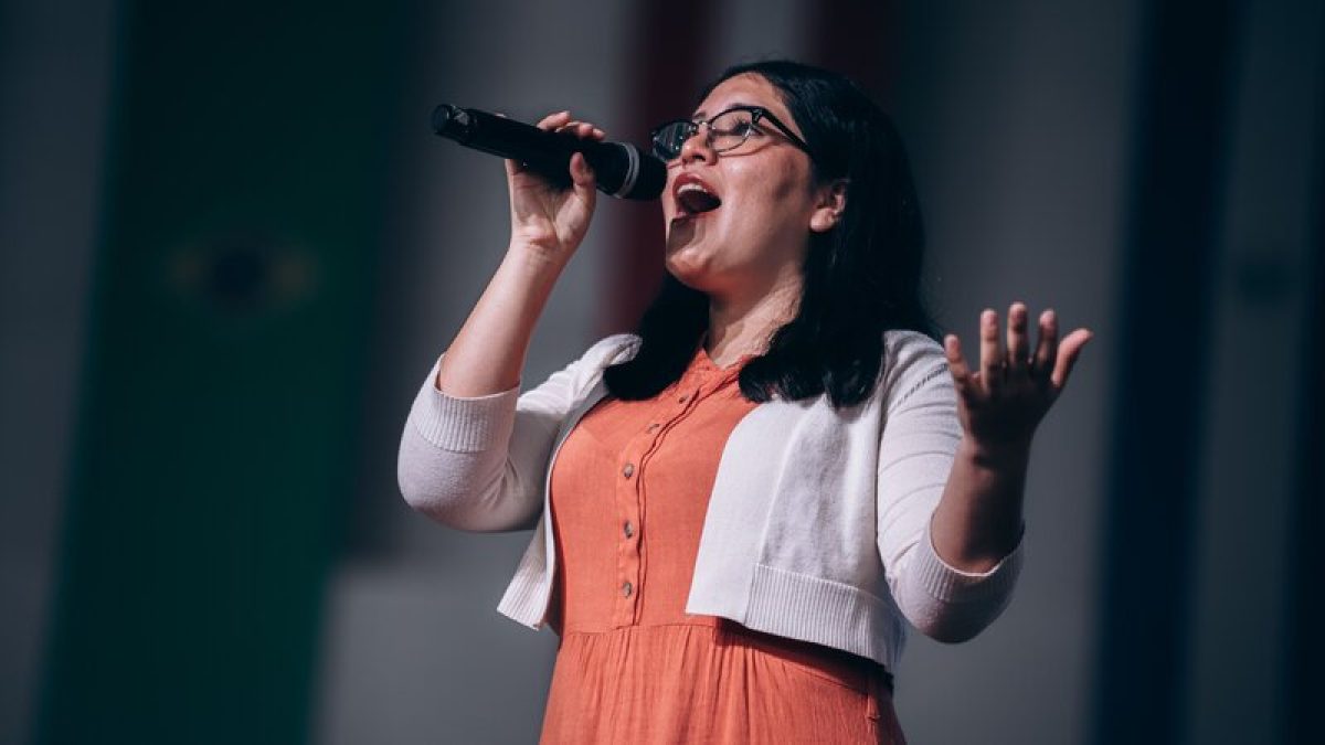 Cantante interpretando una canción frente al micrófono, imagen ilustrativa