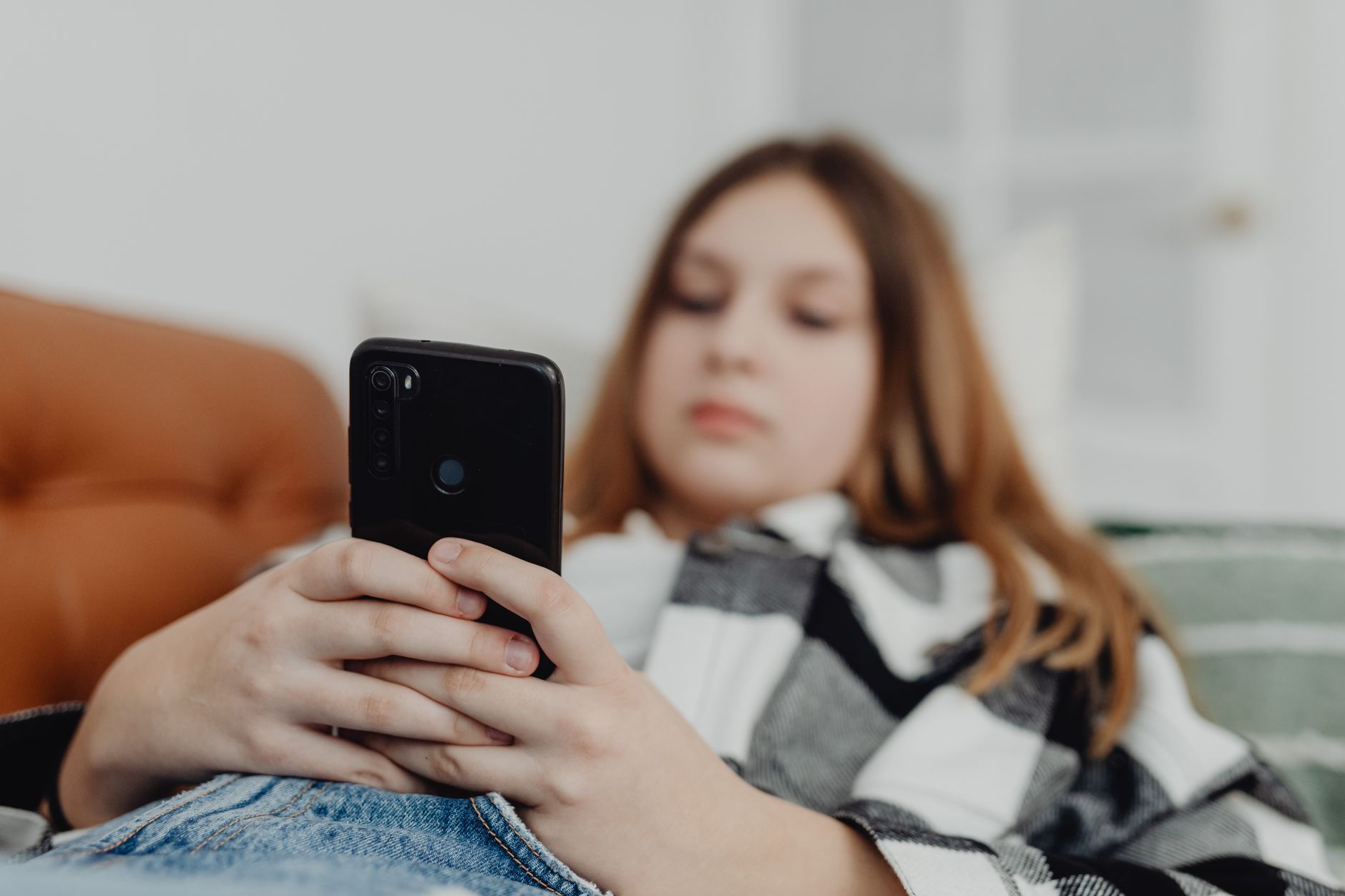 Adolescente usando un teléfono celular con aplicaciones de redes sociales, tema central del decreto para plataformas digitales