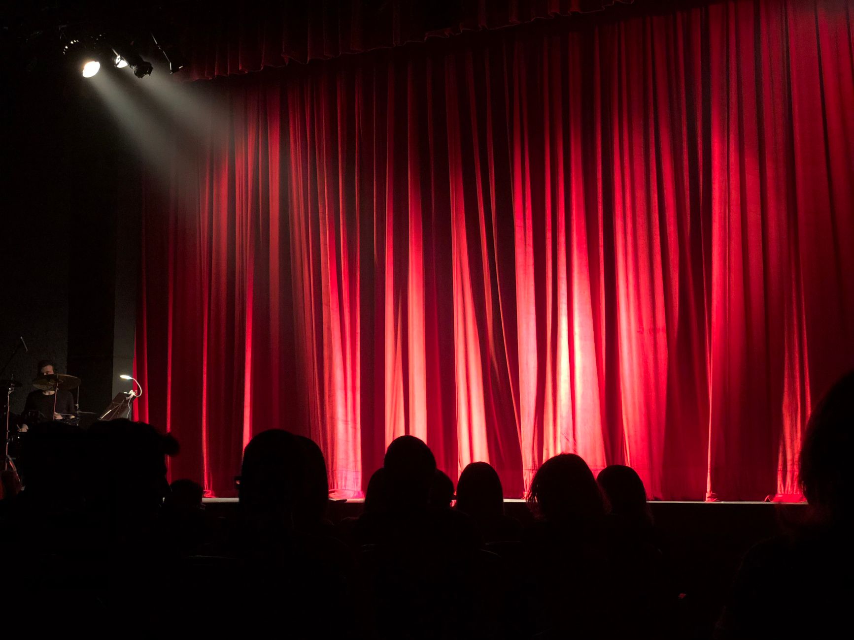 Concierto por un Abrazo en el Teatro Metropólitan: escenario de teatro con cortinas rojas y público
