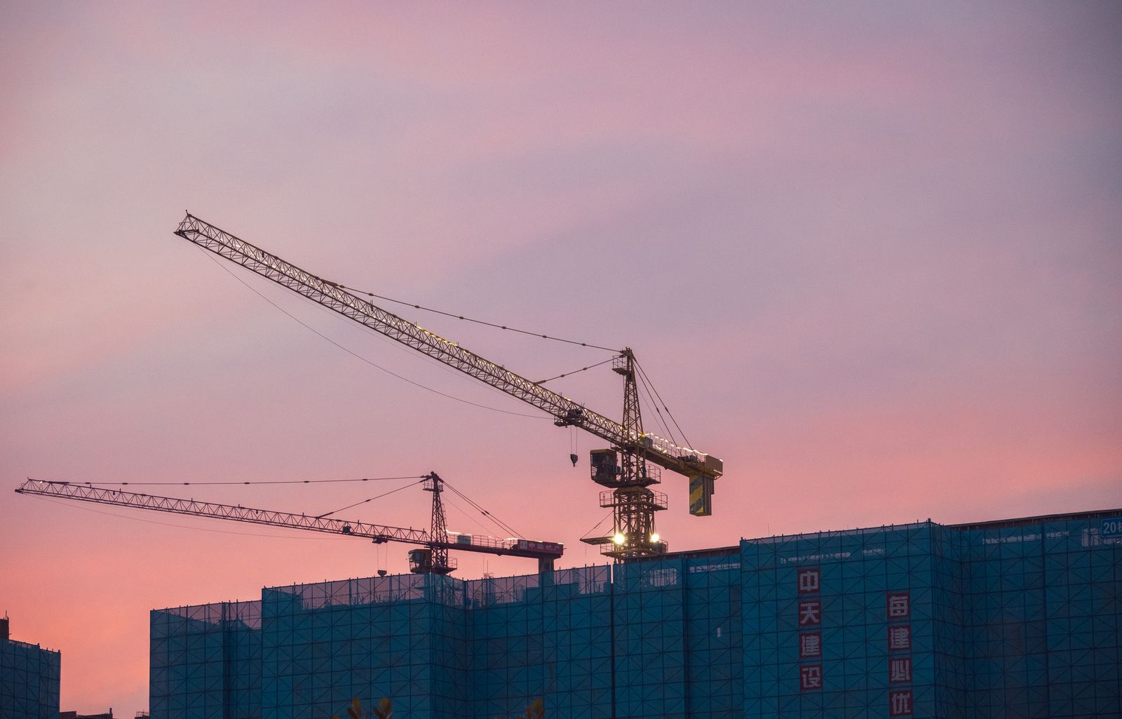 Construcción de grúas sobre un edificio al atardecer, sector que impulsó el IGAE de julio 2026