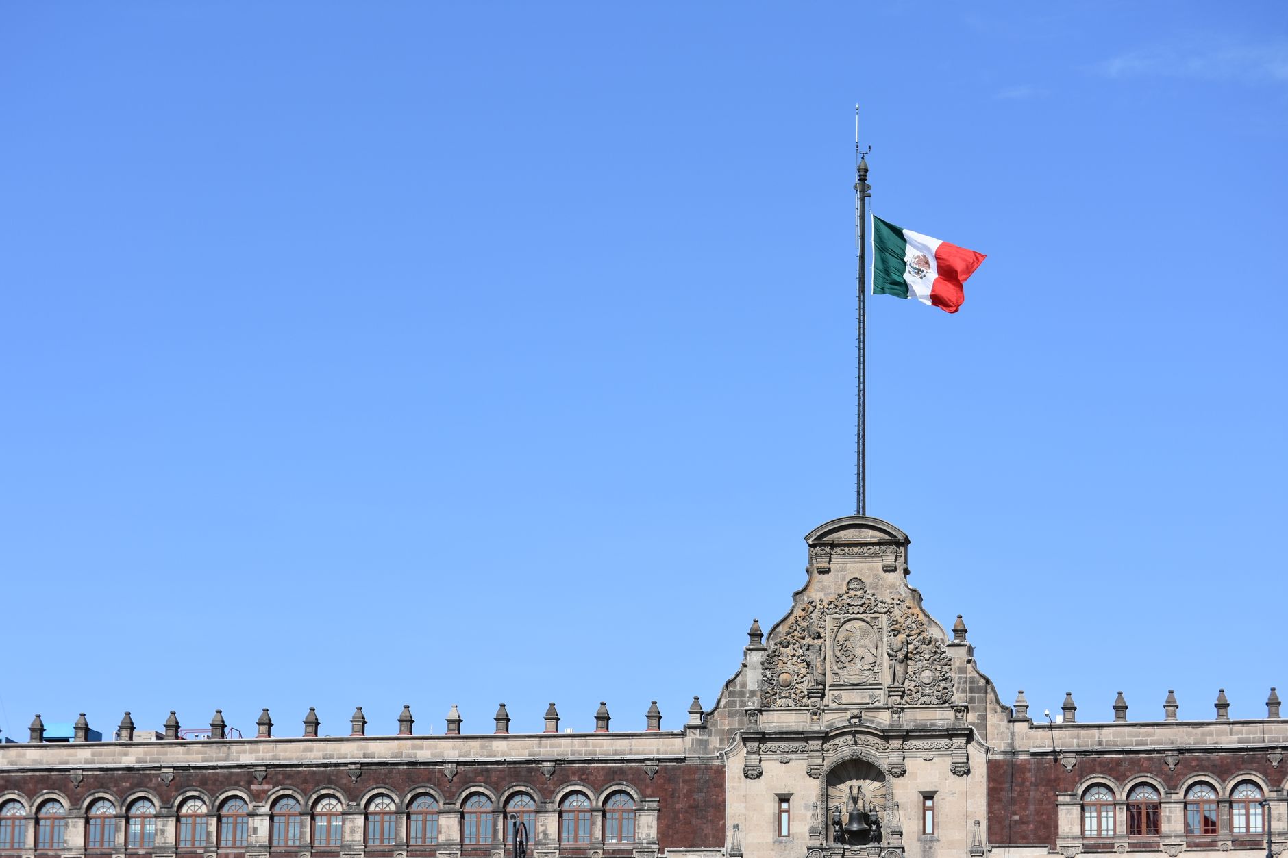 Bandera de México sobre un edificio histórico de la Ciudad de México, ilustración de la confianza en las instituciones