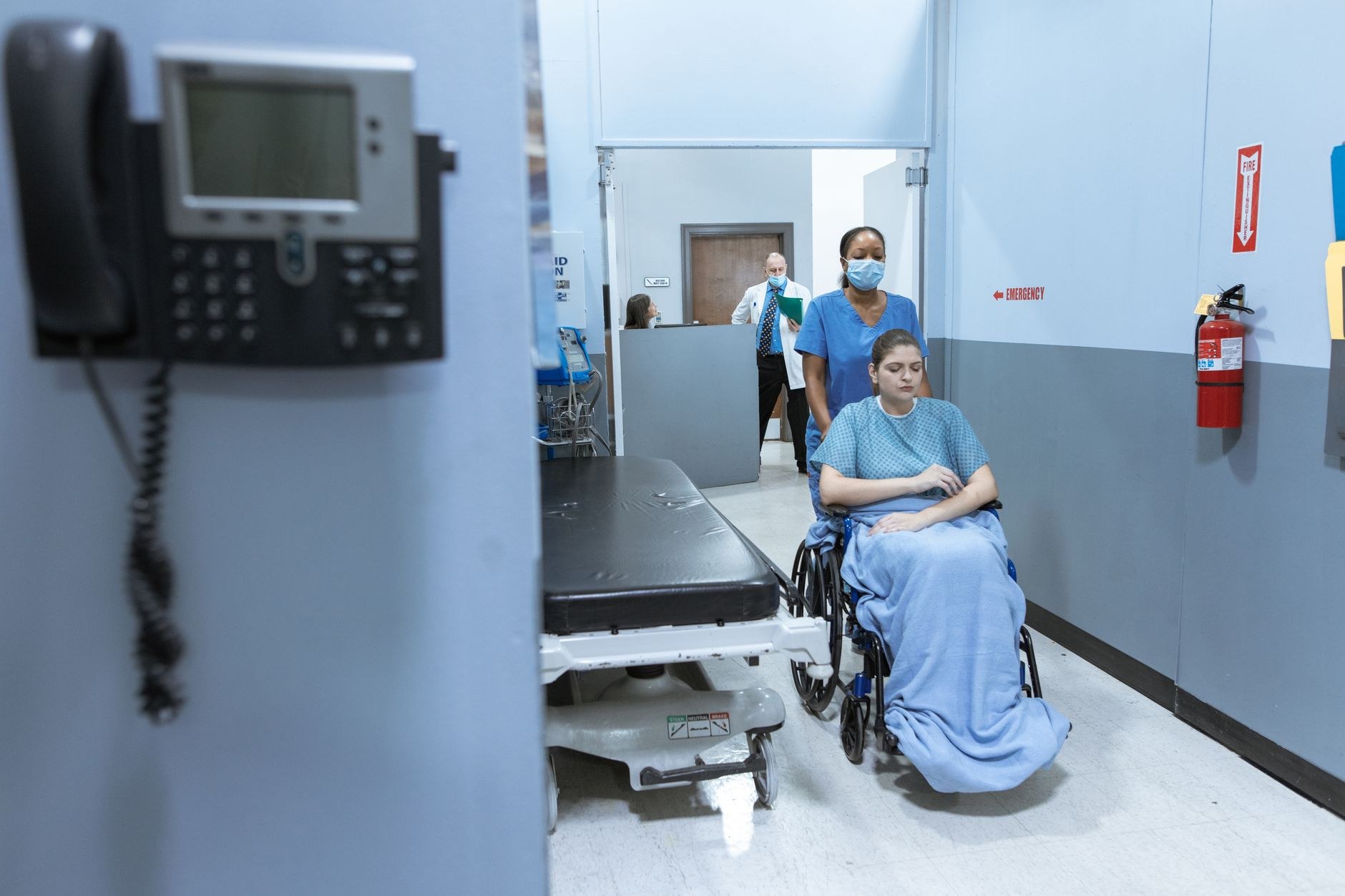 Pasillo de hospital con una paciente en silla de ruedas, ilustración sobre la hospitalización de Laura Bozzo