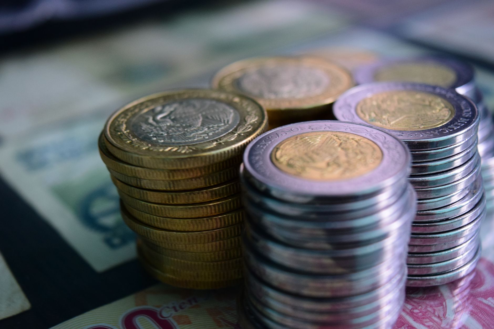 Monedas mexicanas apiladas sobre billetes, imagen de referencia de la recaudación federal de la Ley de Ingresos 2027