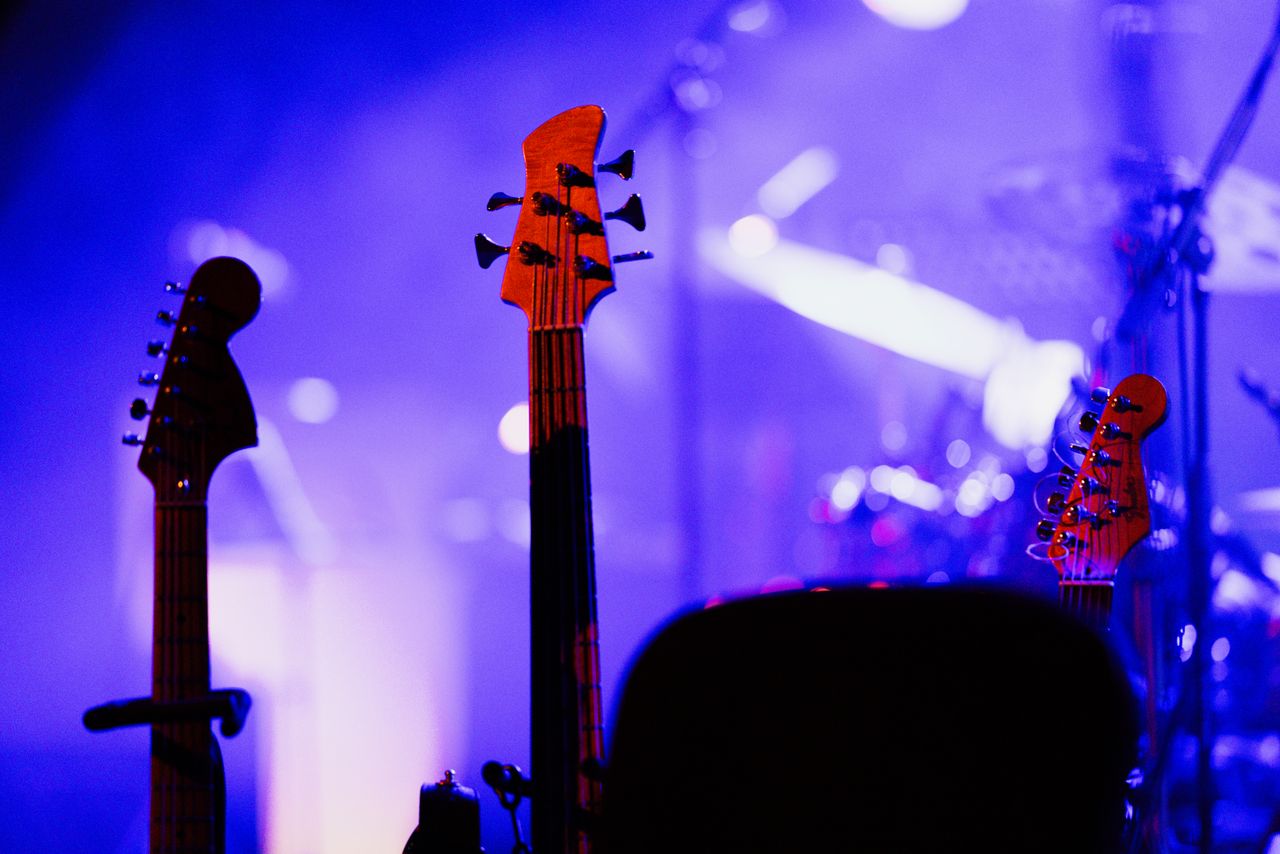 Guitarras eléctricas bajo luces de colores en un escenario de concierto