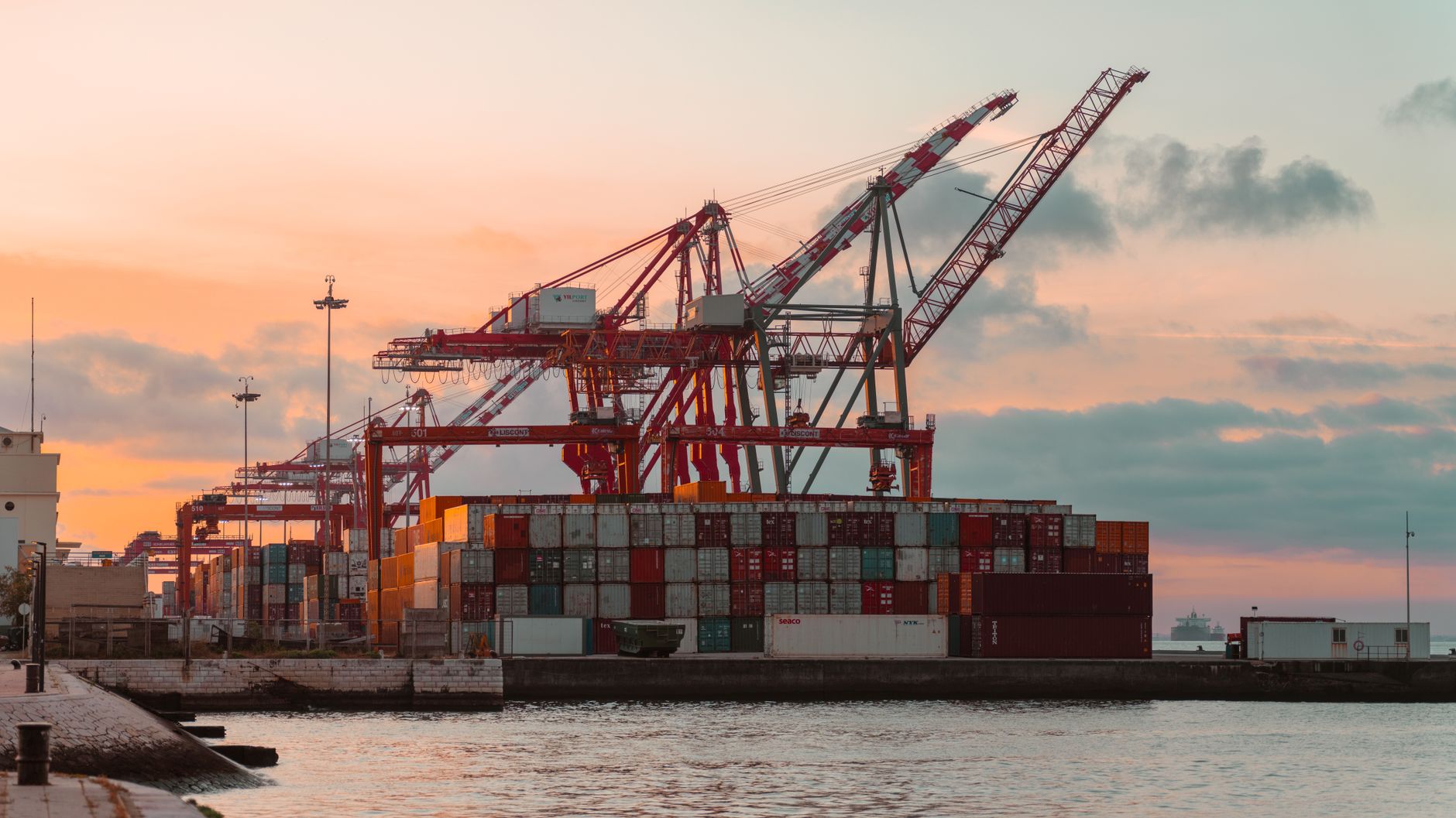 Contenedores y grúas de un puerto de carga al atardecer, imagen de referencia del puerto de Veracruz