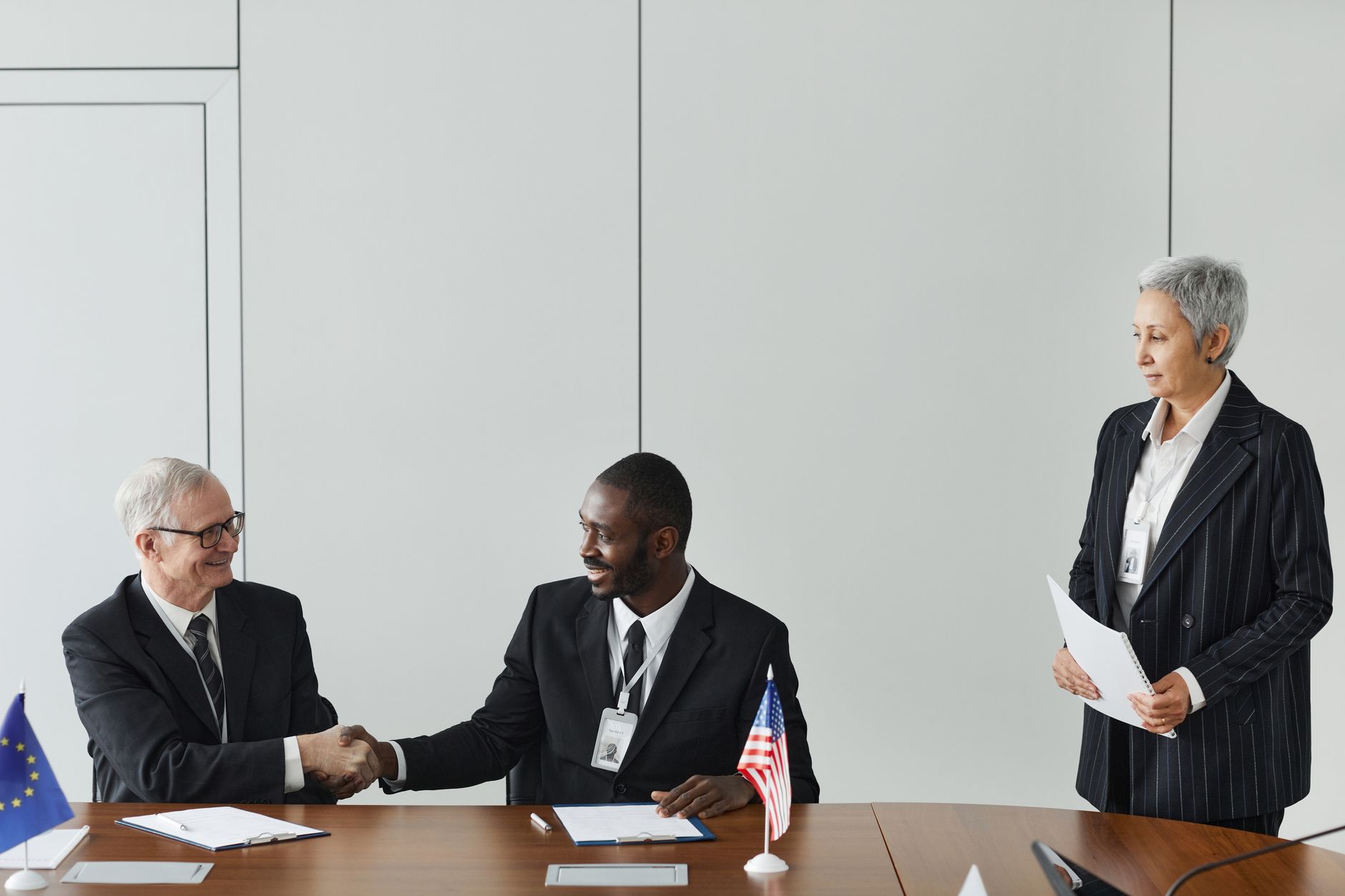 Reunión de negocios multinacional con firma de un acuerdo, imagen ilustrativa del encuentro con empresarios de AmCham