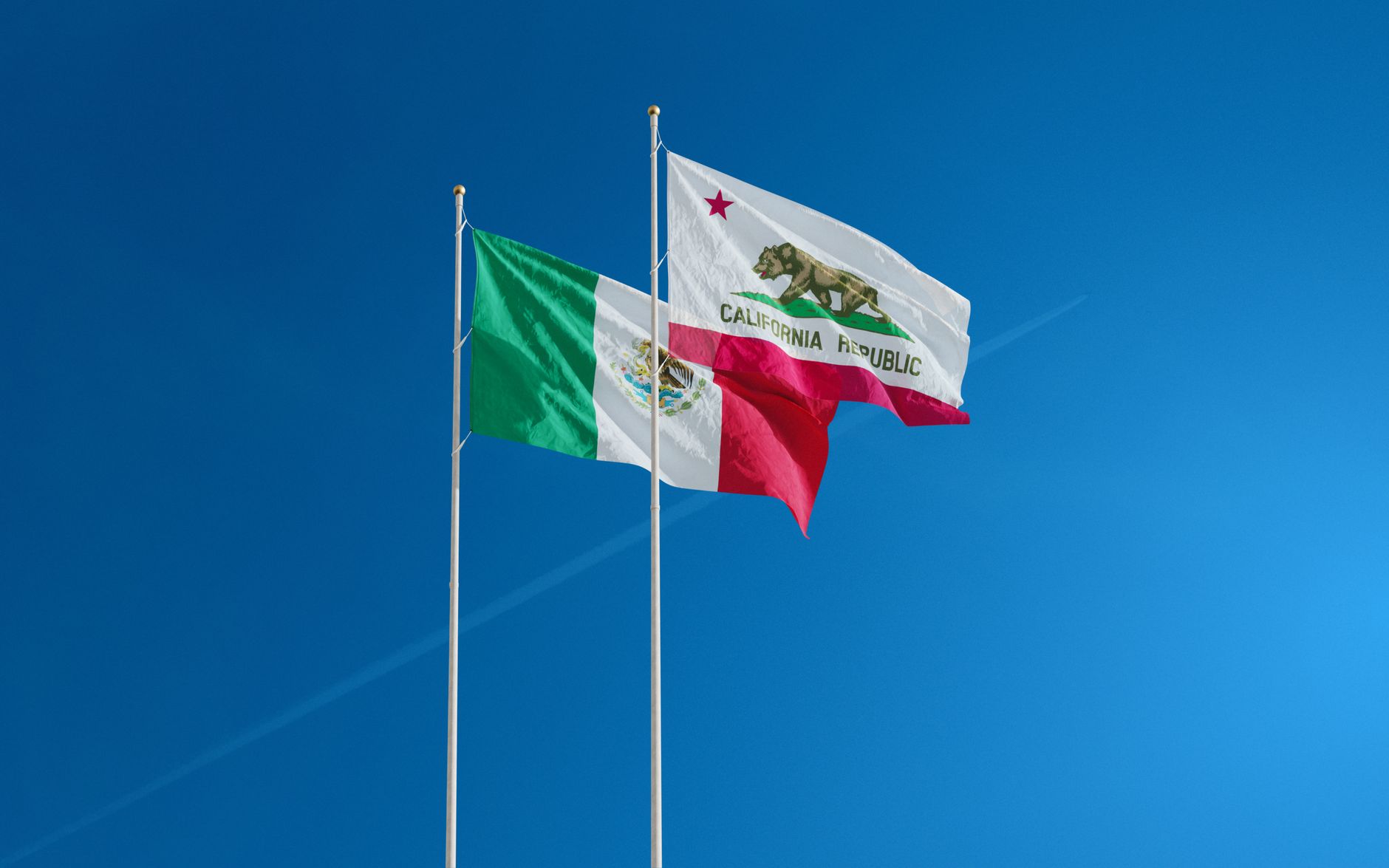 Banderas de México y de California ondeando juntas, imagen ilustrativa de la relación bilateral con Estados Unidos